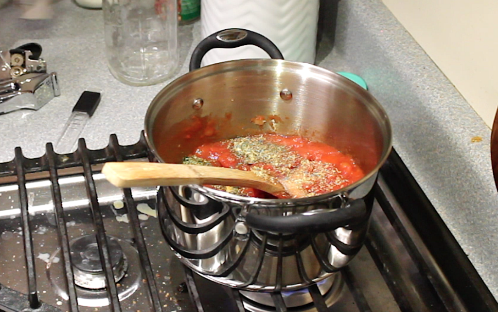 adding spices to spaghetti sauce