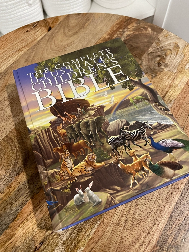 The complete illustrated children's bible laying on wooden table 