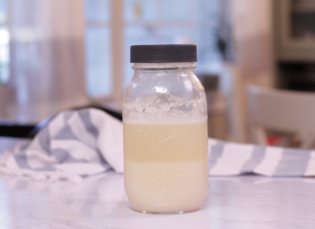 potato flake starter in mason jar on top of counter with stripped tea towel behind
