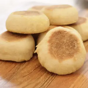 stacked up english muffins on wooden cutting board