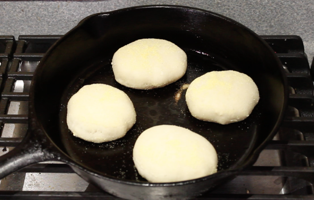 english muffins cooking in cast iron skillet