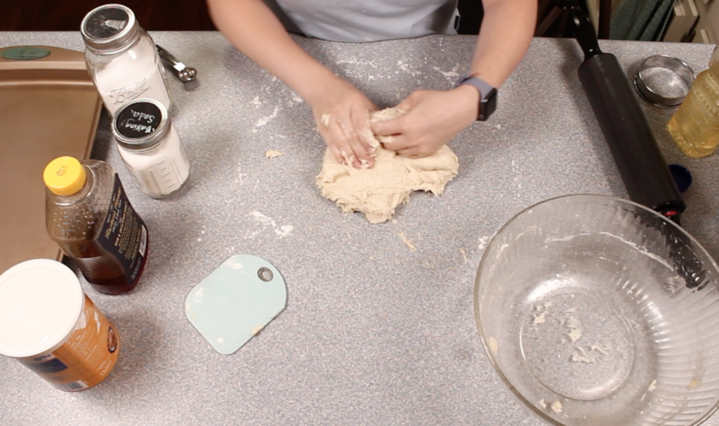 hands incorporating ingredients into dough 