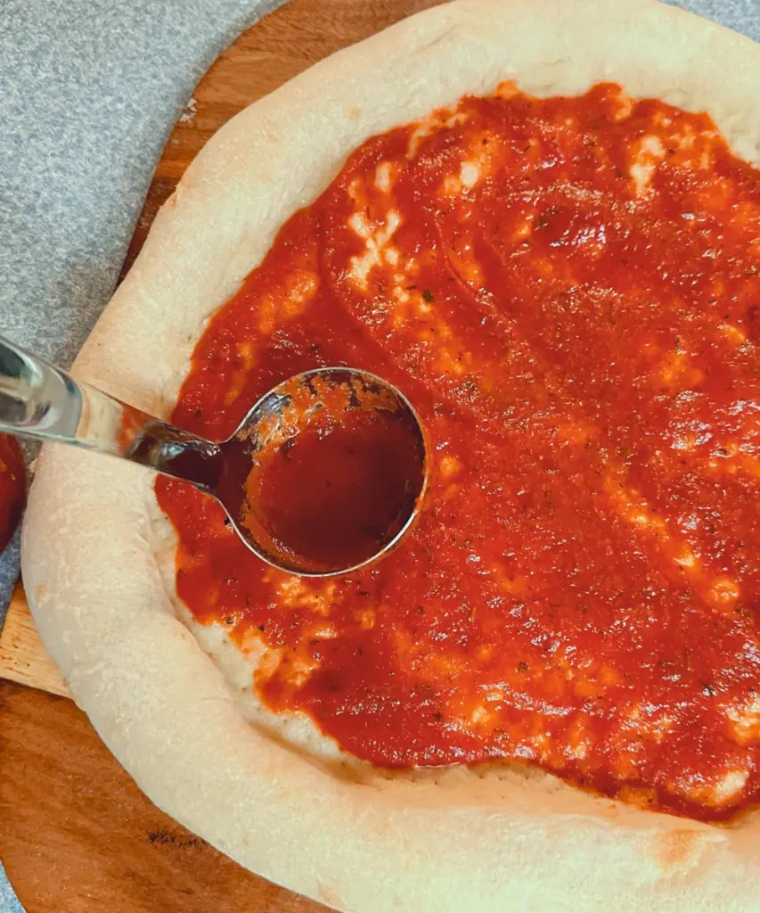 pizza sauce on homemade potato flake sourdough pizza crust