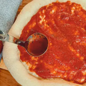 homemade pizza sauce on pizza crust