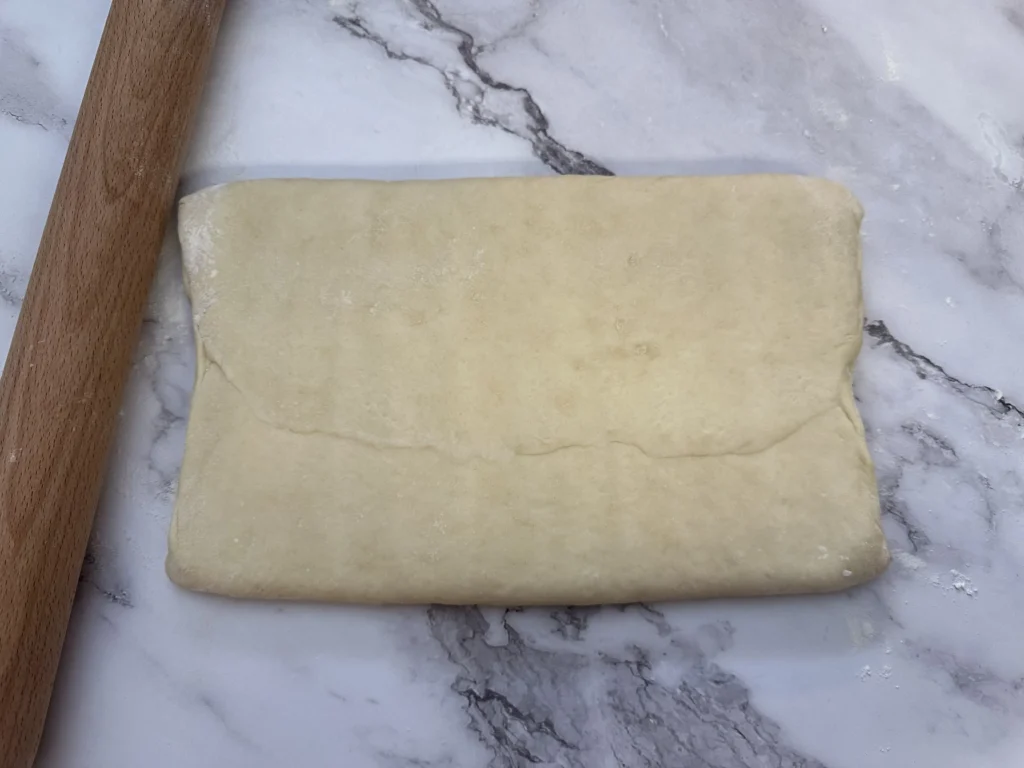 pressing croissant dough out with rolling pin