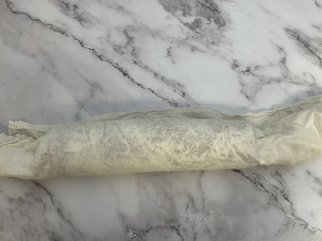 potato flake sourdough pumpkin roll rolled into kitchen towel