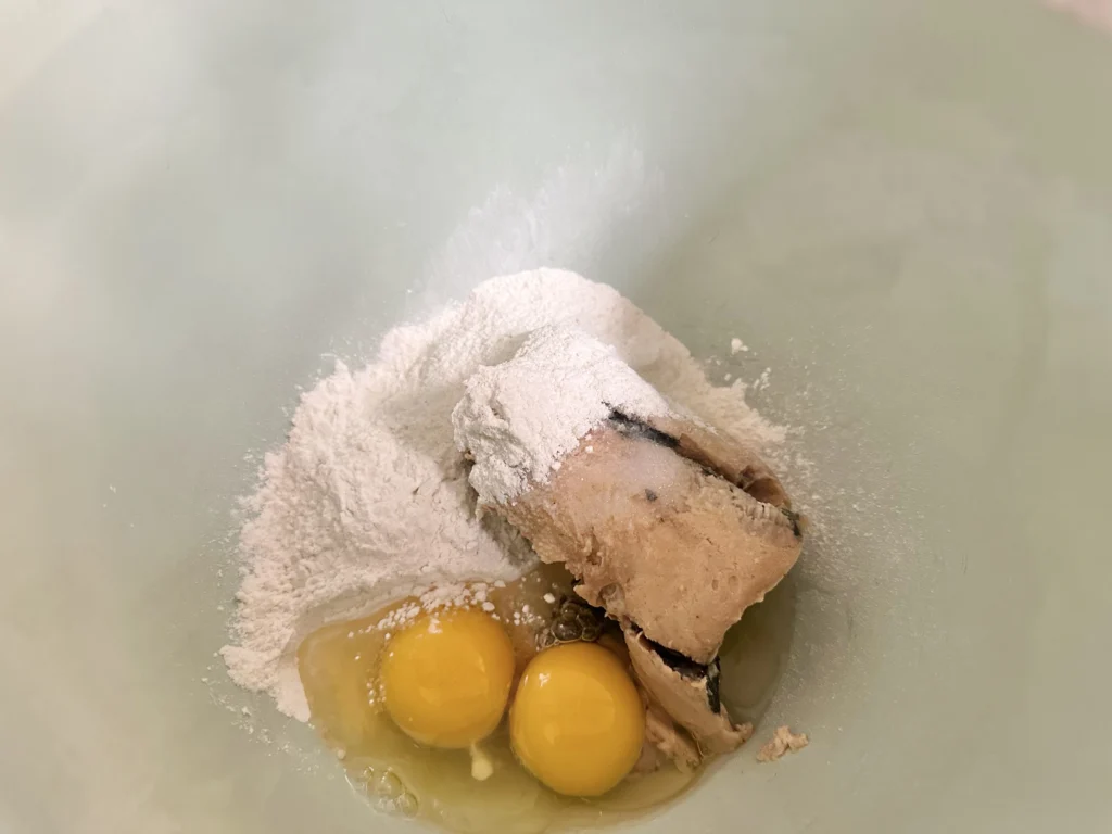 canned salmon and other ingredients for homemade fish sticks in the bowl of a stand mixer