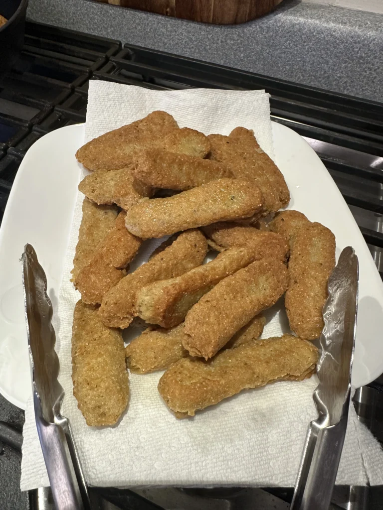 fish sticks draining off excess oil on a paper towel