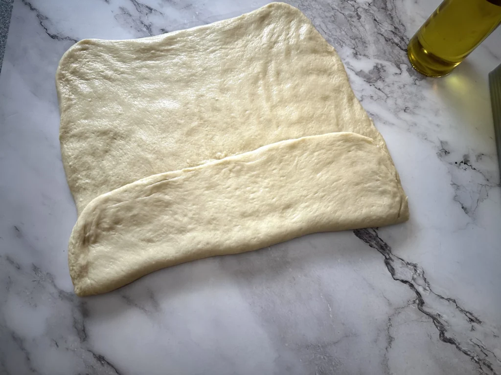 second step in shaping potato flake sourdough loaf for pullman loaf pan