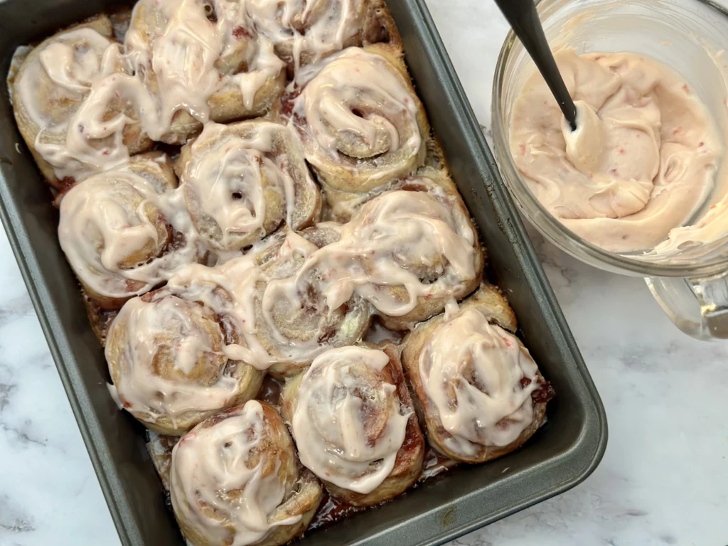 adding icing to cooled rolls