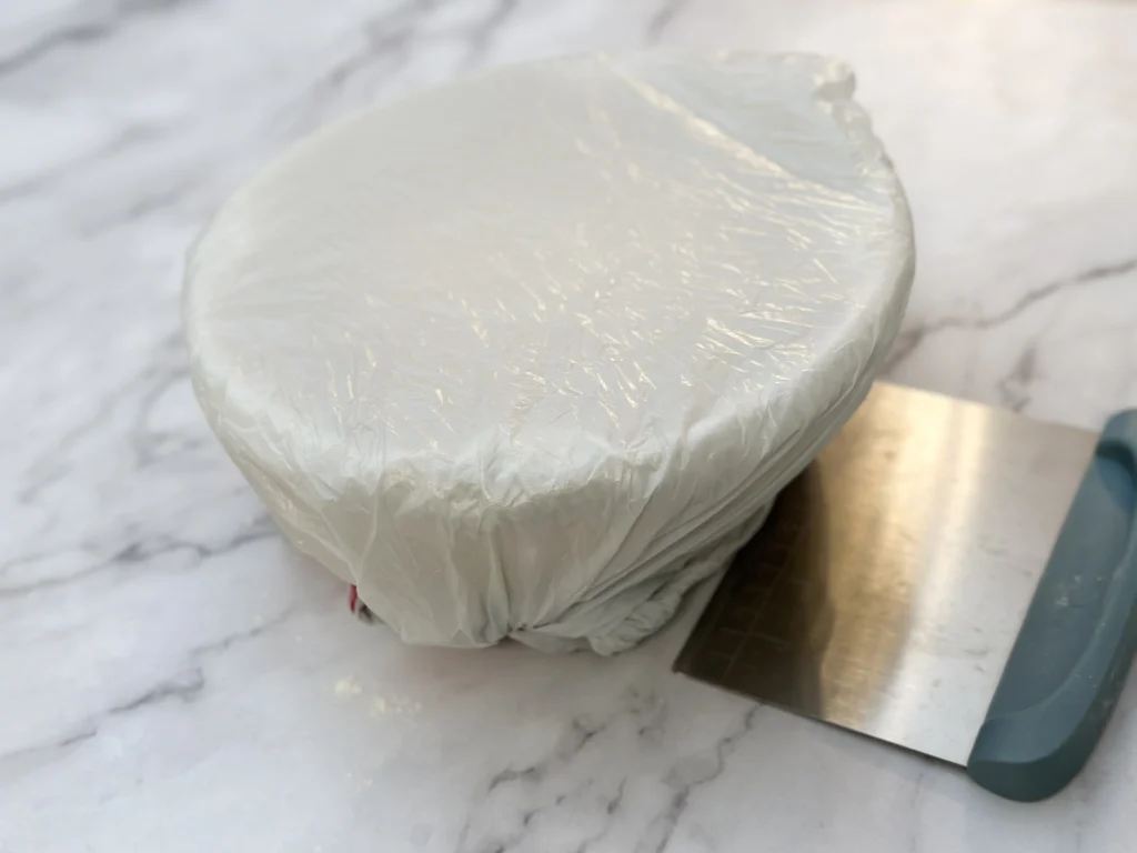 potato flake sourdough Hawaiian bread in bread basket covered with plastic bag