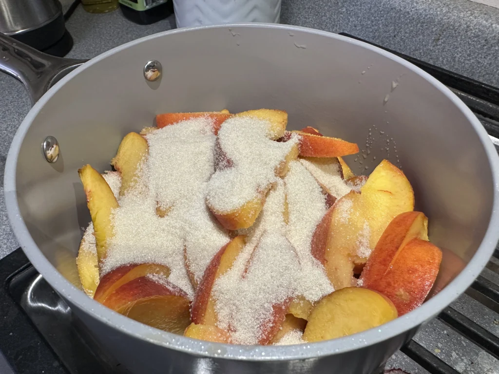 peaches in a pot with sugar on top